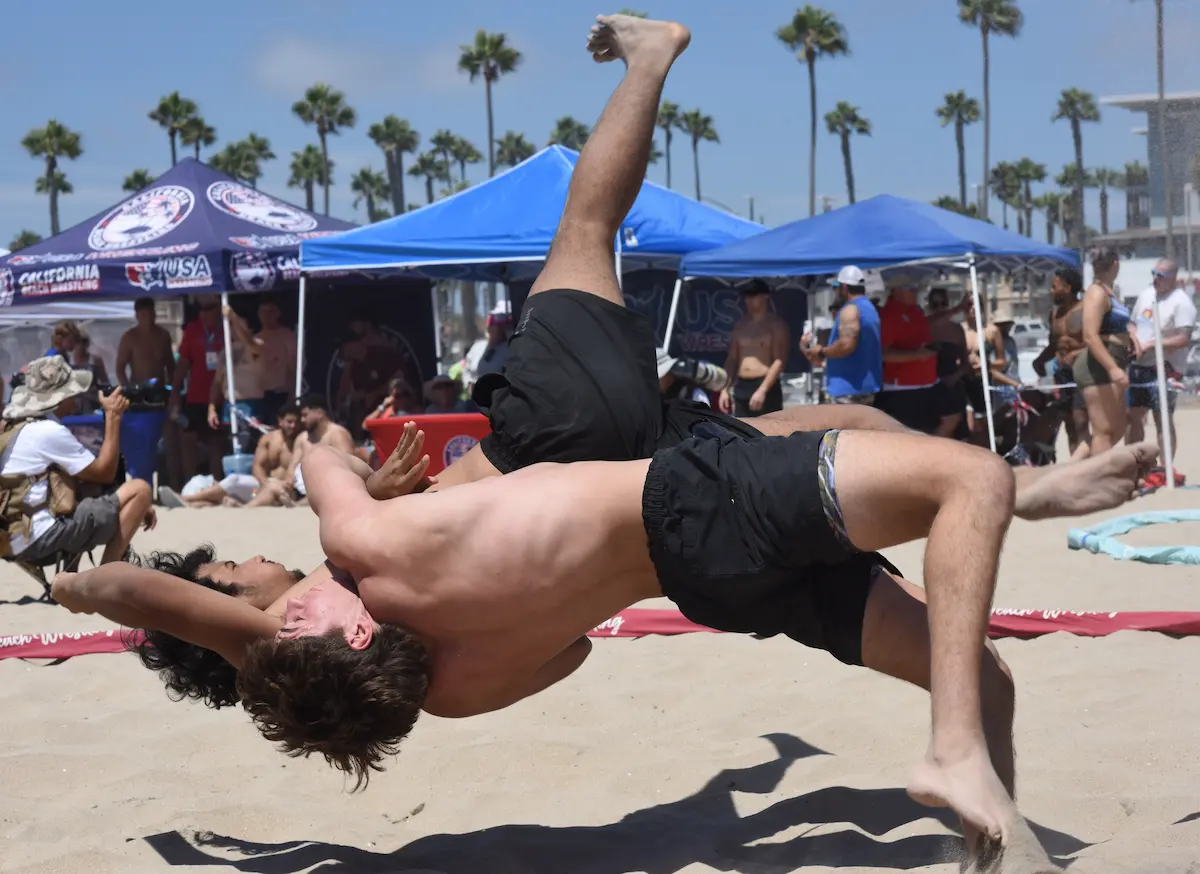 Athletes competing in a USA Beach Wrestling tournament on the sand